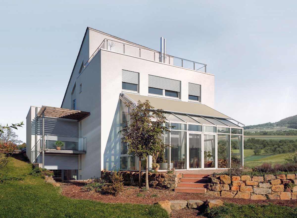 Modernes Einfamilienhaus mit Wintergarten und Gartenlandschaft