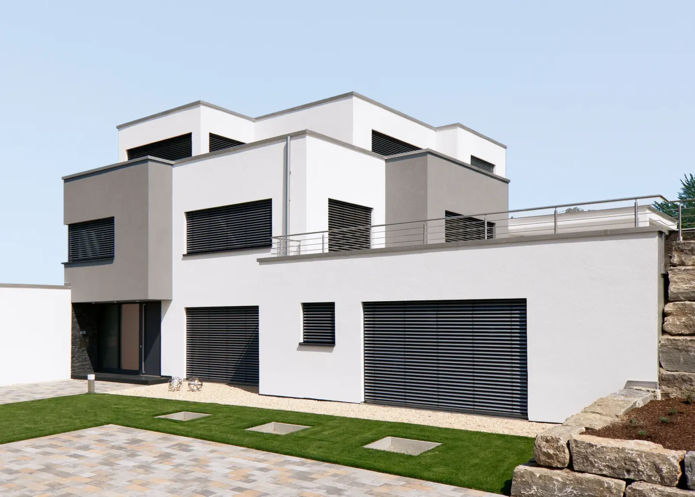 Modernes kubisches Wohnhaus mit dunklen Rollläden