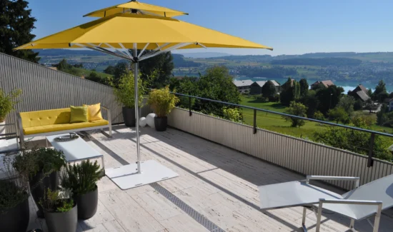 Moderne Terrasse mit gelbem Sonnenschirm und Panoramablick