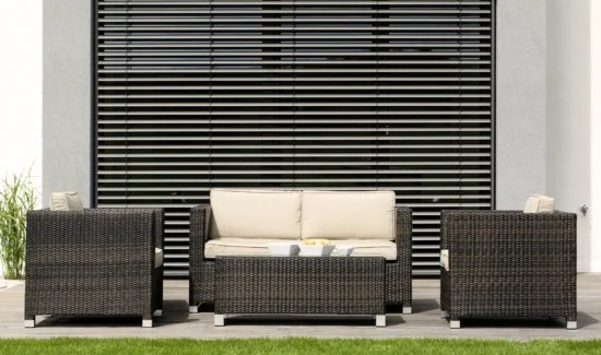 Moderne Outdoor-Sitzgruppe aus Rattan vor einem Fenster mit Jalousien